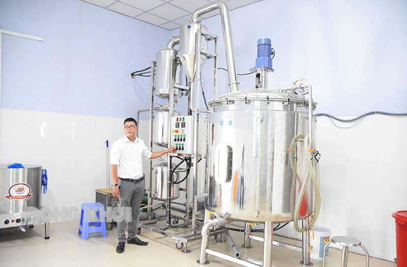 Anh Tô Chí Hải bên máy cô đặc chân không mật dừa.