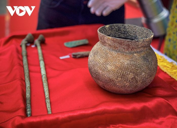 Nồi gốm được xác định niên đại thời Văn hóa Đông Sơn. Nồi miệng loe nhẹ, thân hình cầu, đáy tròn, gốm màu nâu vàng, thân trang trí văn chải.